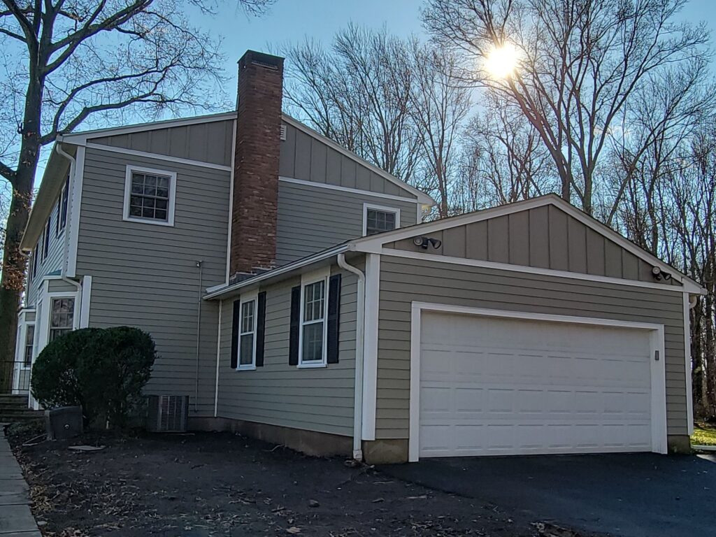 Completed vinyl siding installation with board-and-batten accents on a two-story Connecticut home by MJT Siding.